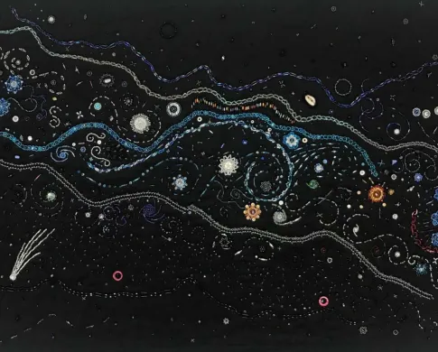 colorful beadwork represents night sky on black background